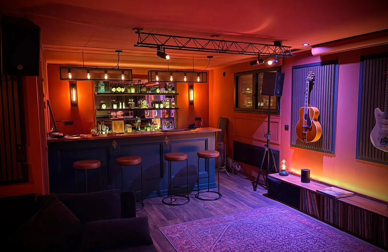 Salle de musique en niveau bas, avec bar et instruments, en ambiance tamisée